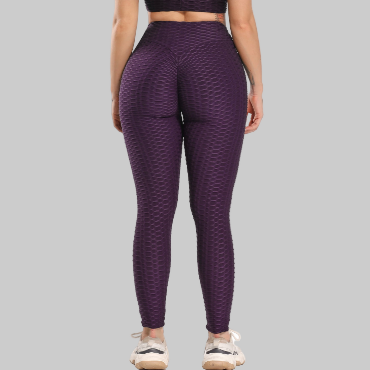 Purple patterned leggings worn by a person on a white background