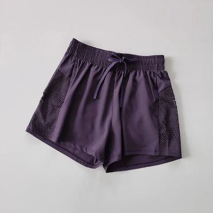 Purple shorts with mesh panels on a light gray background