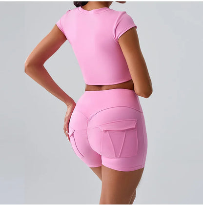 Women's pink sporty set featuring t-shirt and shorts with pockets, ideal for yoga, running, and workout sessions