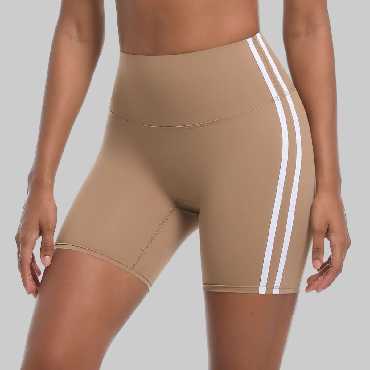 Beige athletic shorts with white stripes on a white background