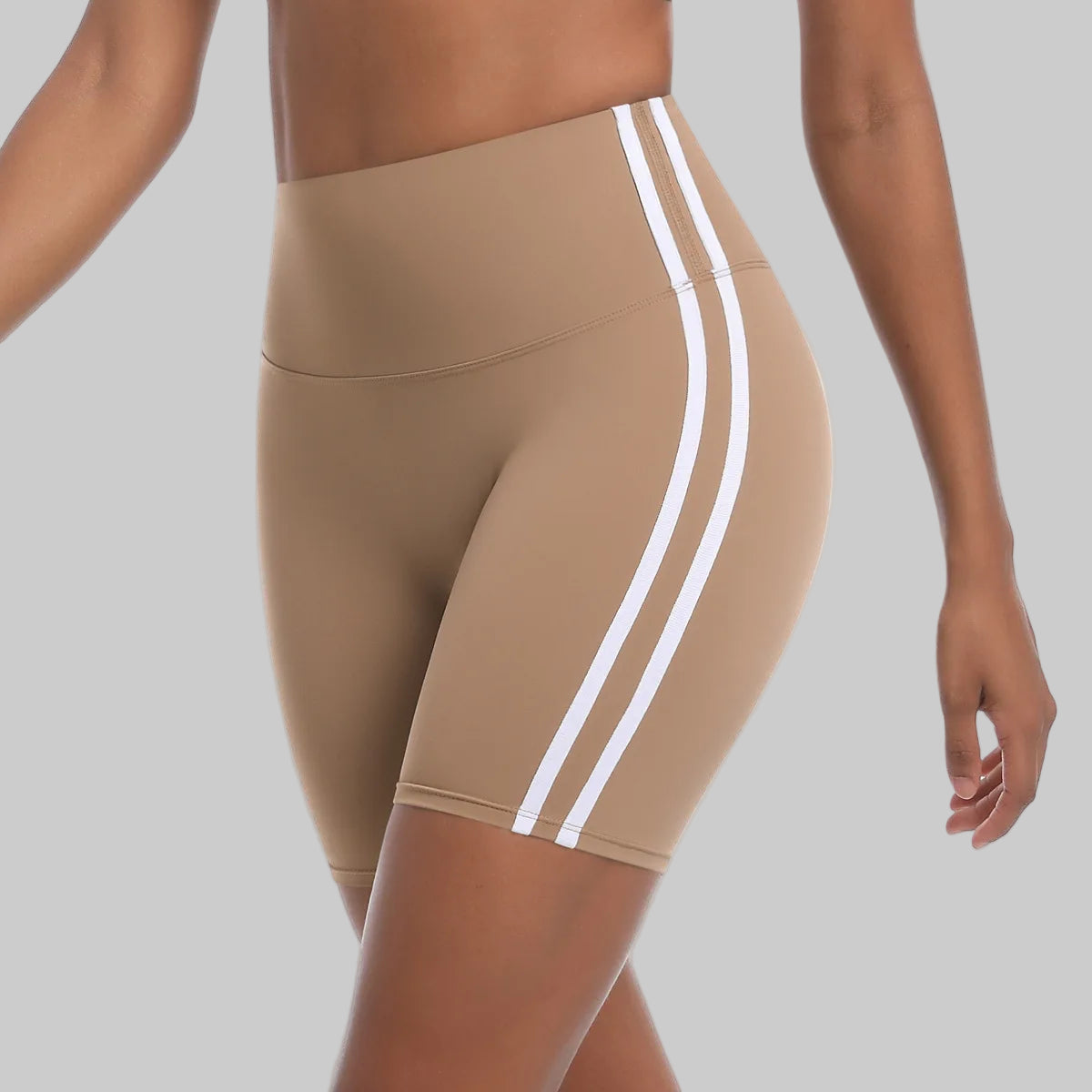 Beige athletic shorts with white stripes on a white background