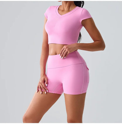 Women's pink workout set with pocketed t-shirt and shorts, designed for gym, Pilates, and all-day comfort