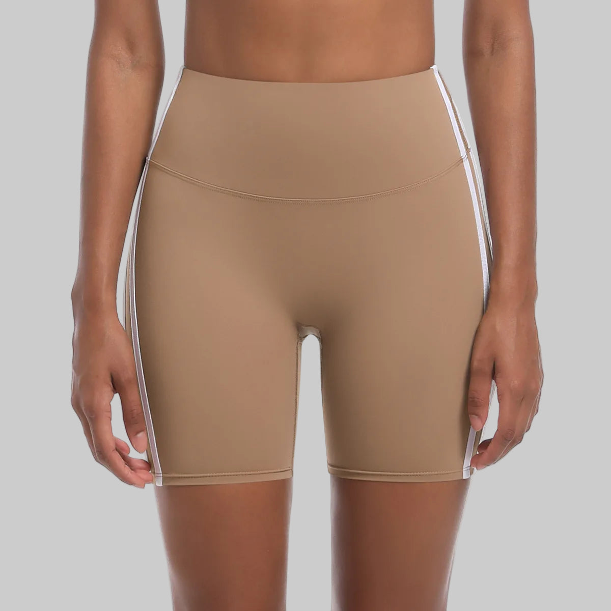 Beige athletic shorts with white accents on a white background