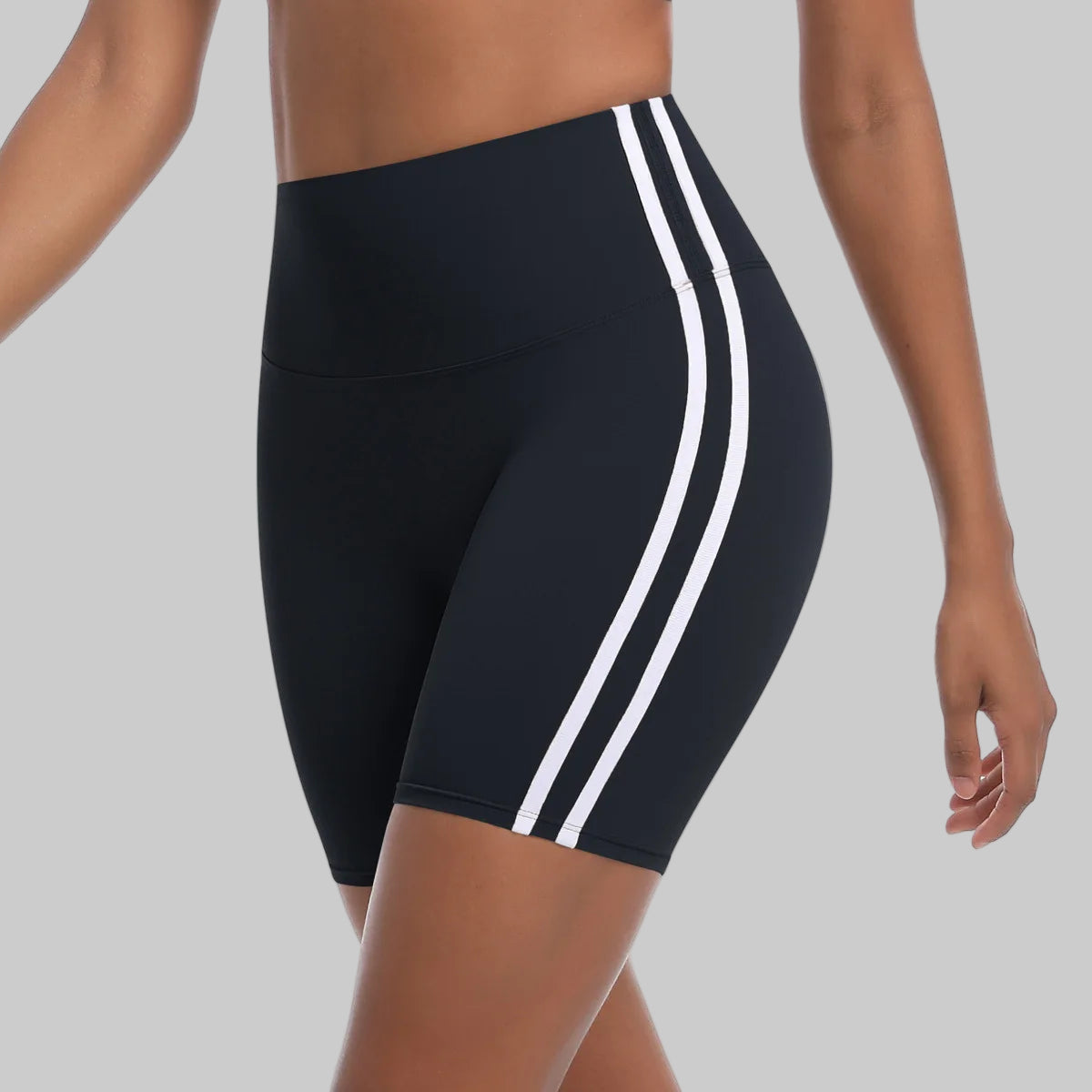 Black athletic shorts with white stripes on a white background