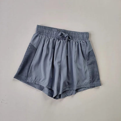 Blue shorts with mesh panels on a light gray background