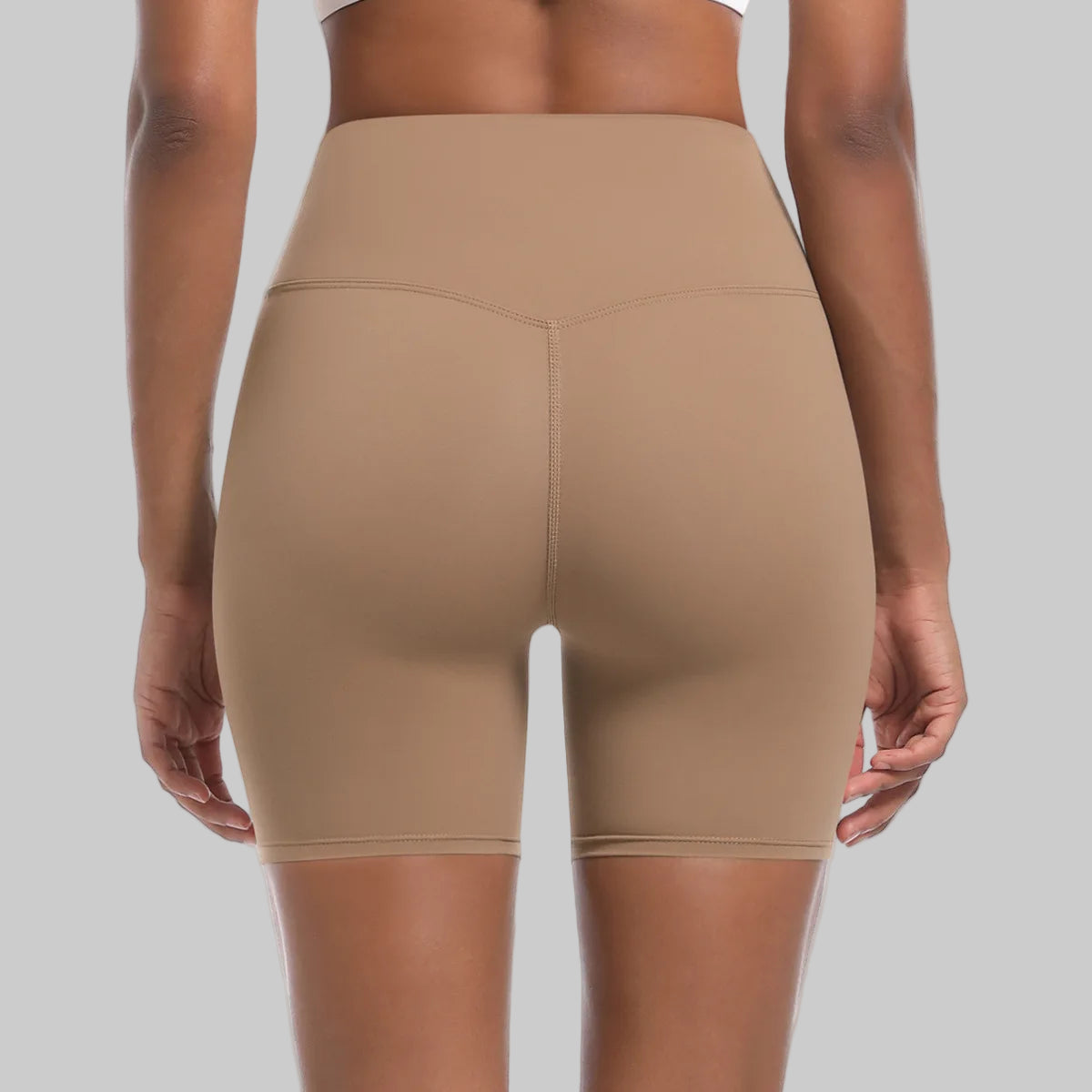 Beige high-waisted shorts worn by a person on a white background