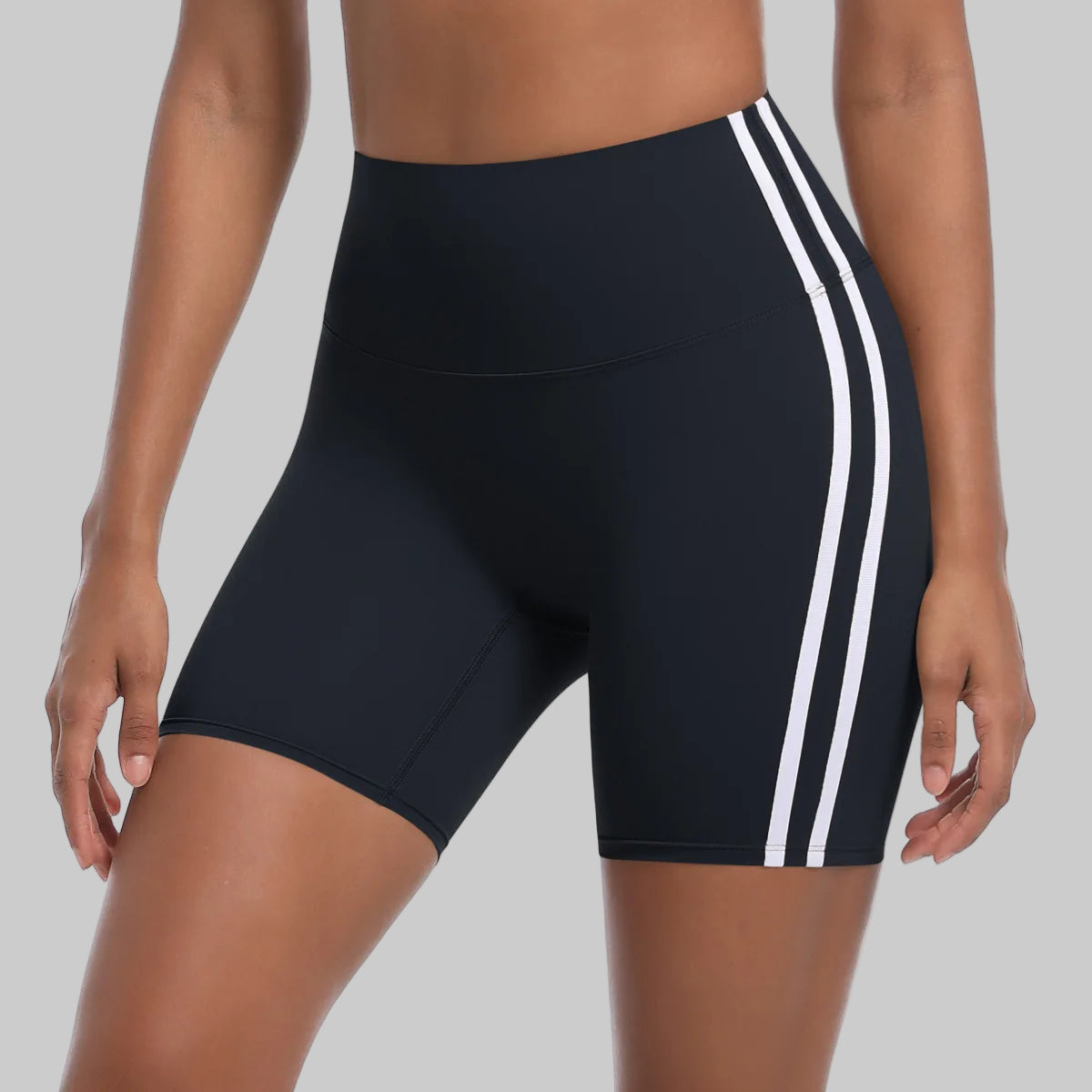 Black athletic shorts with white stripes on a white background