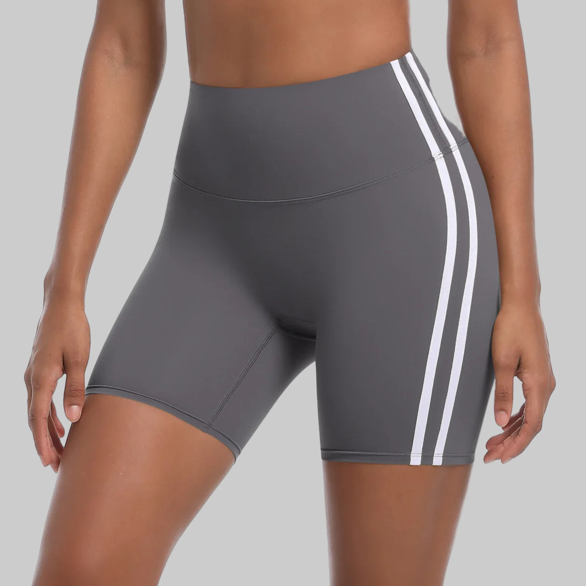 Gray athletic shorts with white stripes on a white background
