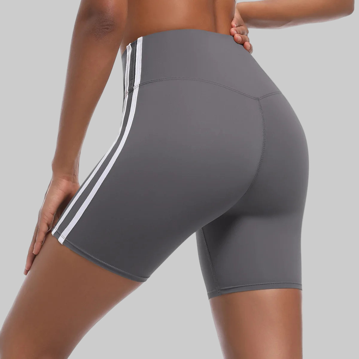 Gray athletic shorts with white stripes on a white background