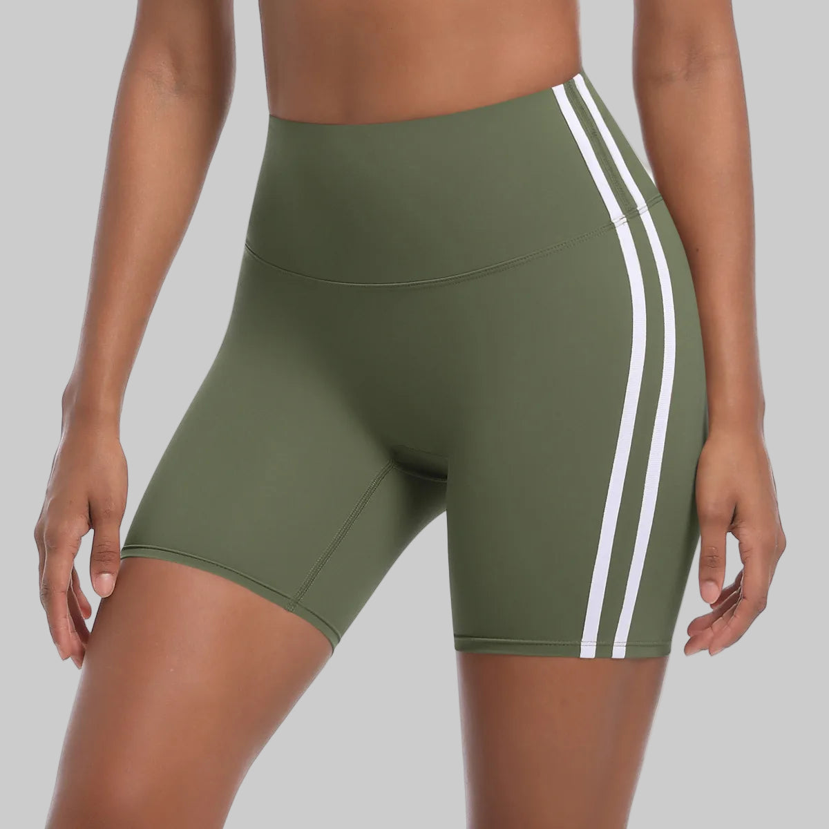 Green athletic shorts with white stripes on a white background